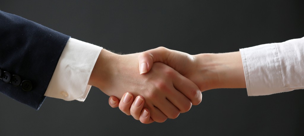 Business handshake on dark background